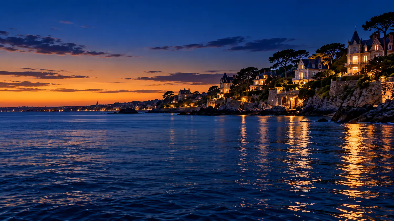 La côte de Dinard à l'heure bleue, villas Belle Époque éclairées au-dessus d'une mer calme